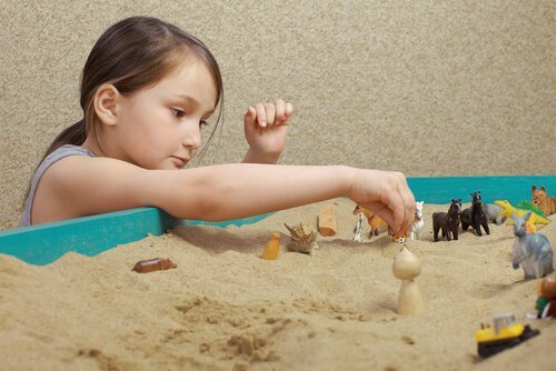 Ein Mädchen spielt in einer Sandkiste. 