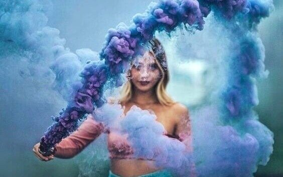 Ein Mädchen, das von blau-lila Nebel umgeben ist