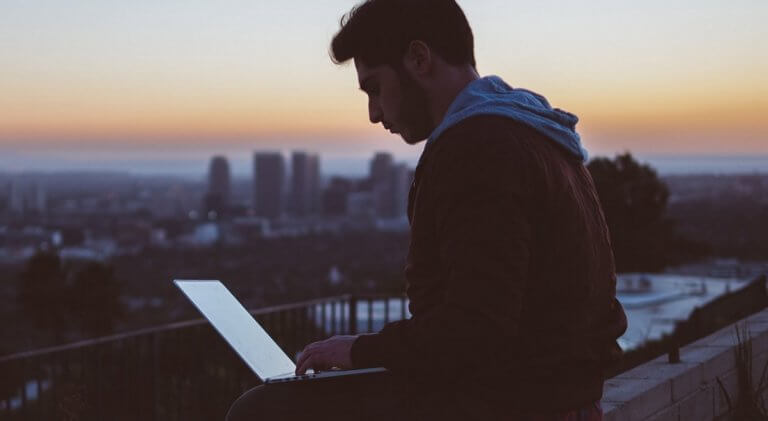 Mann sitzt am Laptop.
