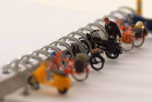 Mit Leichtigkeit: Ein Spielzeugmann parkt sein Spielzeugmotorrad.