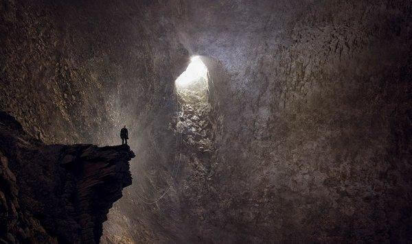 Mann in einer Höhle, der Richtung Ausgang blickt