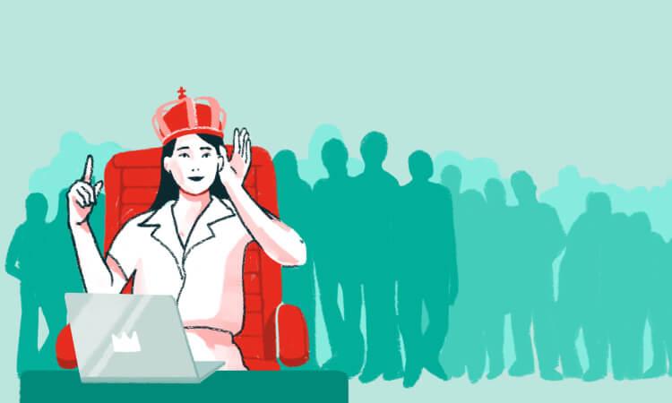 Frau mit Krone sitzt an einem Laptop