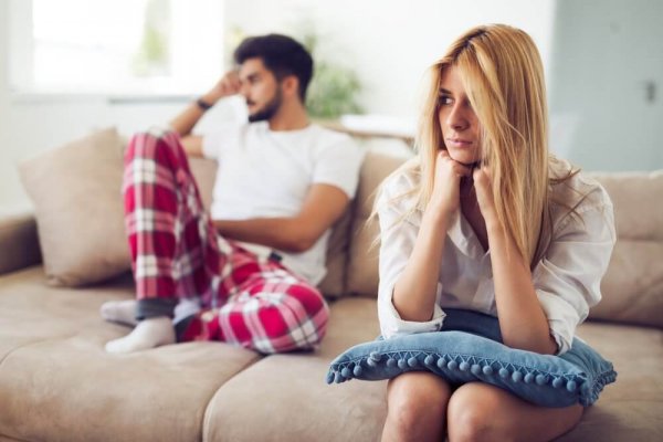 Ein Paar sitzt frustriert auf einer Couch.