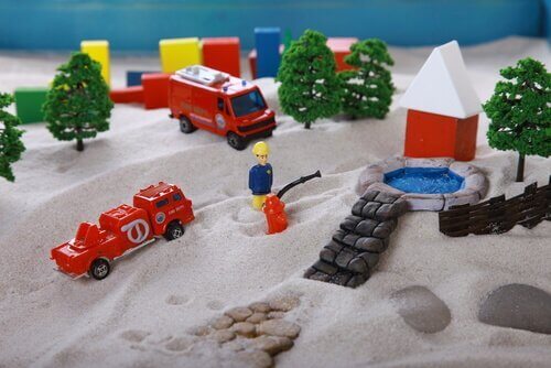 Eine Sandkiste mit Playmobil-Figuren.