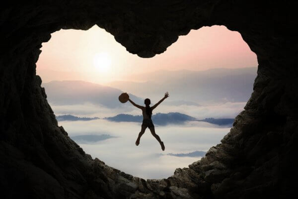 Eine Person springt in einer herzförmigen Höhle.