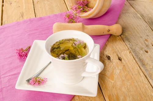 Teetasse mit Baldriantee steht auf Holztisch.