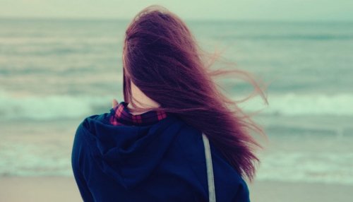 Teenager steht am Meer.