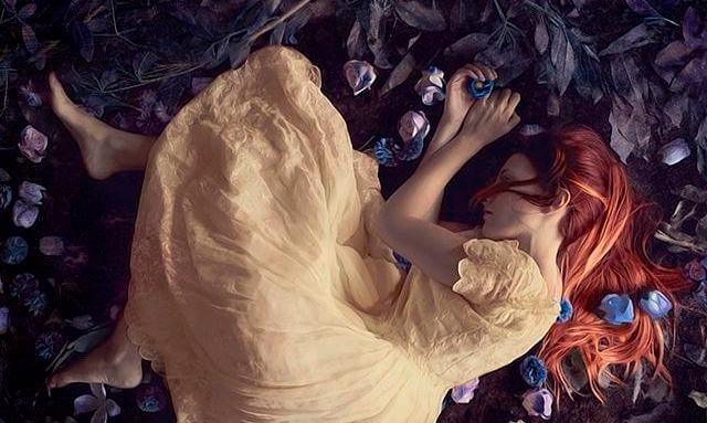 Rothaarige Frau liegt erschöpft auf dem Boden