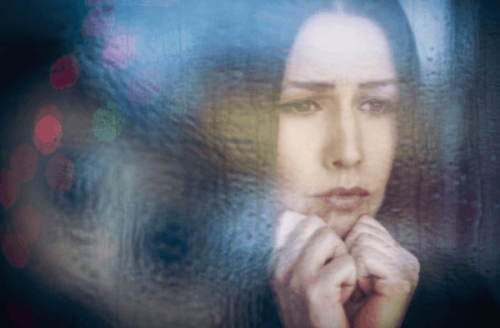 Frau mit Dysthymie schaut aus dem Fenster
