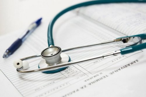 Foto eines Stethoskops und Kugelschreibers, die auf einem Krankenblatt liegen