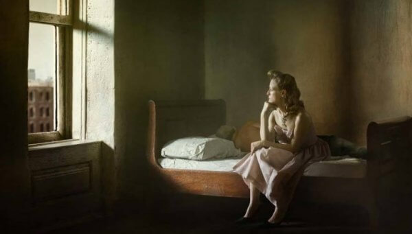 Ein Gemälde von Edward Hopper, das eine Frau zeigt, die auf einem Bett sitzt und gedankenverloren durch ein Fenster blickt. 