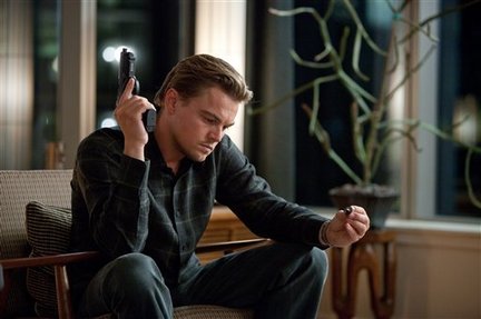 Dom Cobb, die Hauptfigur aus "Inception", hält eine Waffe in der einen Hand und in der anderen ihr Totem.