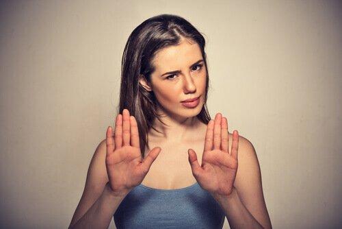 Frau wehrt mit deutlichen Handzeichen ein Näherkommen ab