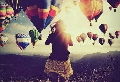 Frau umgeben von vielen Heißluftballons
