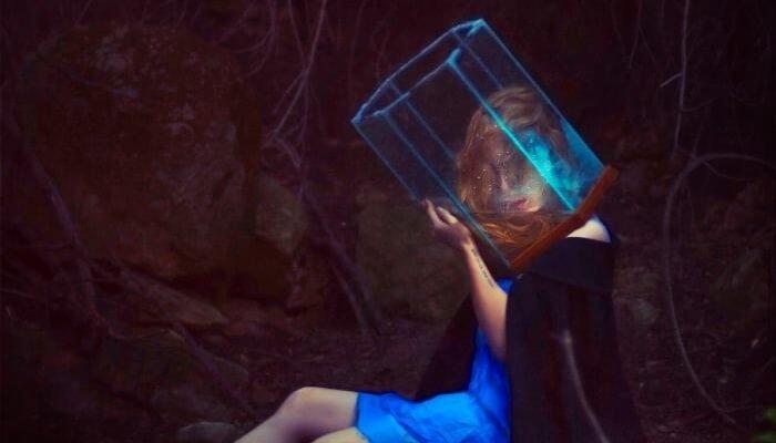 Frau im blauen Kleid trägt einen Wasserbehälter über den Kopf gestülpt