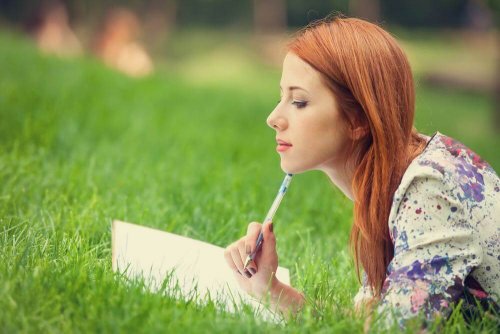 Frau schreibt im Gras
