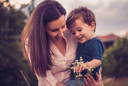 Mutter und Sohn schauen sich eine Blume an