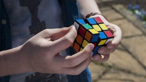 Junge trainiert räumliche Intelligenz mit einem Zauberwürfel.