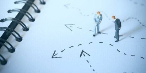 Miniaturmänner betrachten Pfeile auf dem Boden, die den Wunsch nach Kontrolle versinnbildlichen.