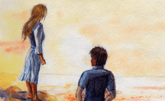 Paar steht gemeinsam am Strand und schaut aufs Meer