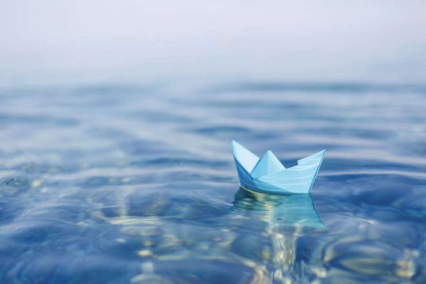 Schiff aus Papier, das auf dem Wasser schwimmt