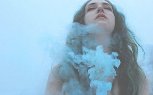 Von blauem Rauch umgebenes Mädchen