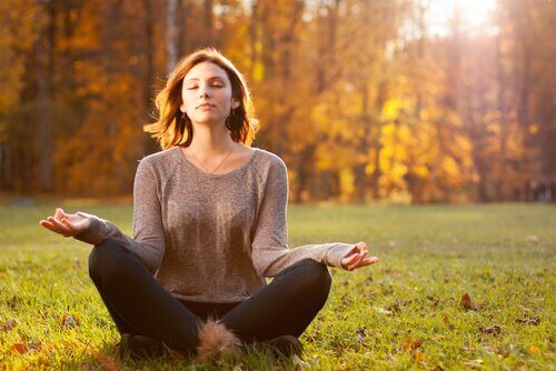 Eine Frau praktiziert Yoga in einem Wald.