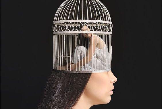 Frau sitzt ängstlich in einem Käfig