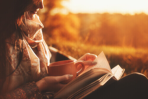 Frau trinkt Tee und liest ein Buch