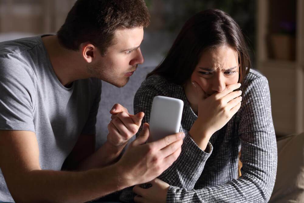 Mann zeigt seiner Partner böse ihr Handy