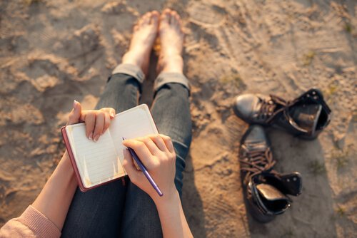 Frau schreibt am Strand