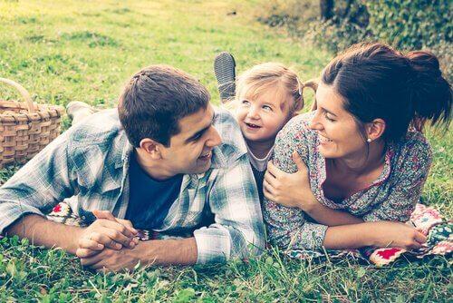 Mutter und Vater mit ihrem Kind auf einer Wiese