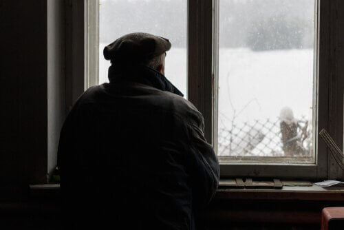 Mann mit Morbus Alzheimer schaut aus dem Fenster