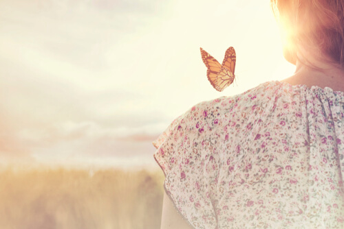 Frau mit Schmetterling auf ihrer Schulter