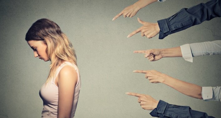 Taktiken der Manipulation: Eine Frau fühlt sich schuldig, alle Finger weisen auf sie