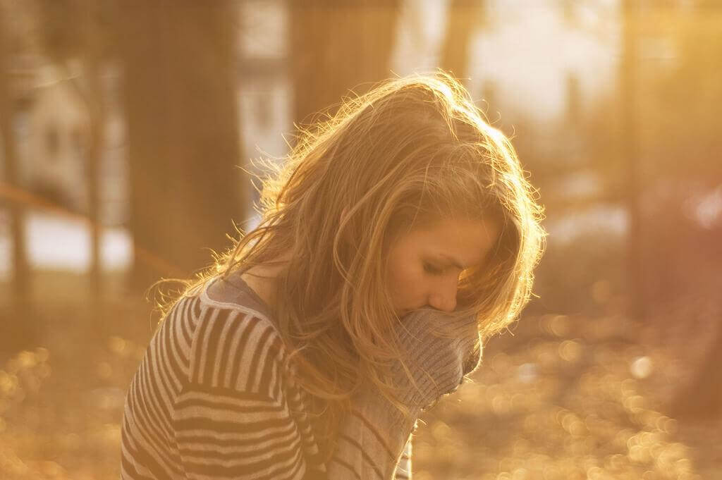 Frau steht verlassen in einem Wald