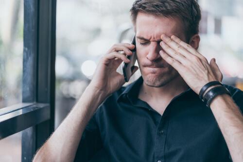 Zorniger Mann telefoniert mit seinem Handy