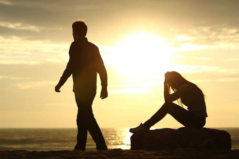 Zerstrittenes Paar am Strand bei Sonnenuntergang