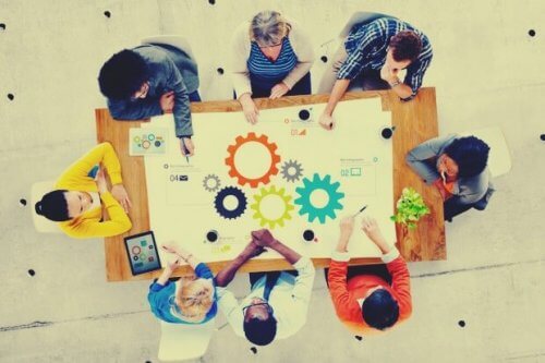 Mehrere Mitarbeiter sitzen an einem Tisch und tauschen Ideen aus.