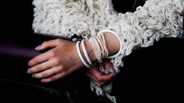 Ein Mädchen trägt einige Armbänder ums Handgelenk.