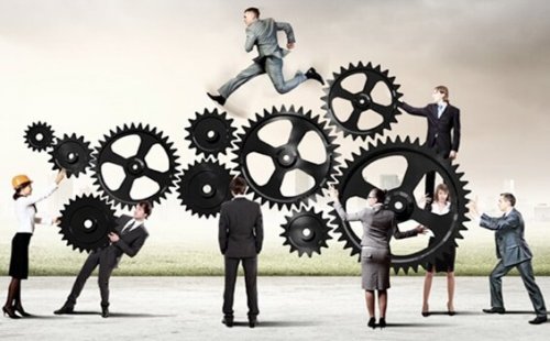 Menschen unter Zahnrädern, während einer über sie hinwegläuft