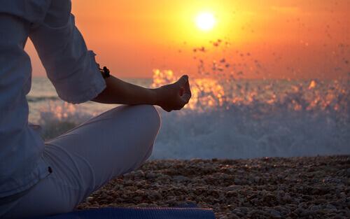 Frau praktiziert Mindfulness am Meer