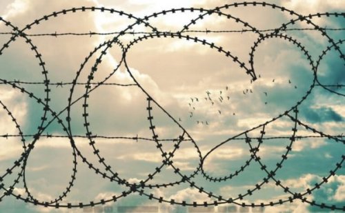 Stacheldrahtzaun mit herzförmigem Loch