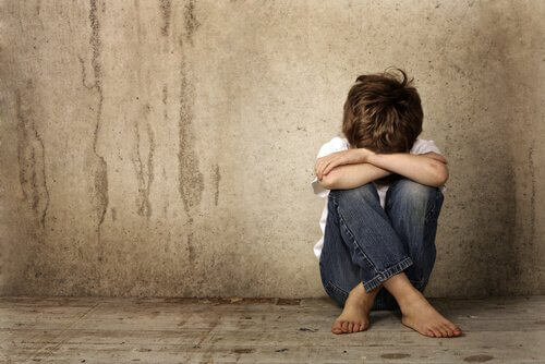 Trauriger Junge sitzt allein auf dem Boden
