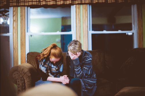 Zwei Frauen trauern auf einer Couch