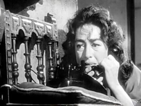 Filmszene aus Baby Jane, die Joan Crawford zeigt, wie sie am Telefon nach Hilfe verlangt