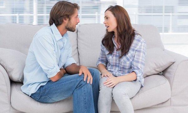 Paar spricht auf dem Sofa über Beziehungsprobleme.
