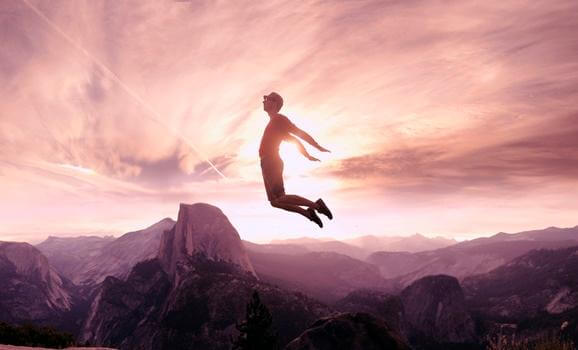 Mann, der über Berge springt