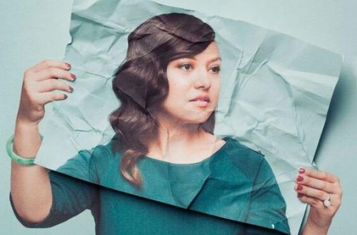 Frau hält ein Foto vor sich.