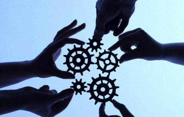 Menschliche Hände halten Zahnräder.